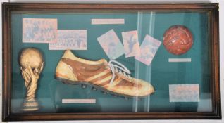 A glass case containing synthetic examples of 1930's style of soccer apparel etc. Printed