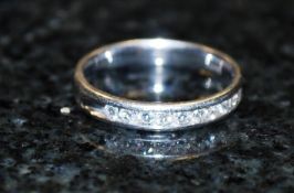 A 14ct gold diamond half eternity channel set ring. The centre set stones to the 14ct gold hoop.