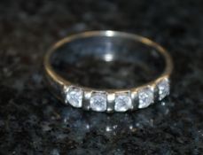 A 9ct gold and 25pts diamond channel set ring. The five central set 5 stones on the gold hoop