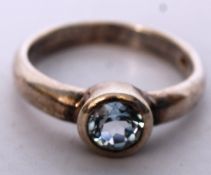 A silver 925 white metal ring with aquamarine ring to the clasp centre