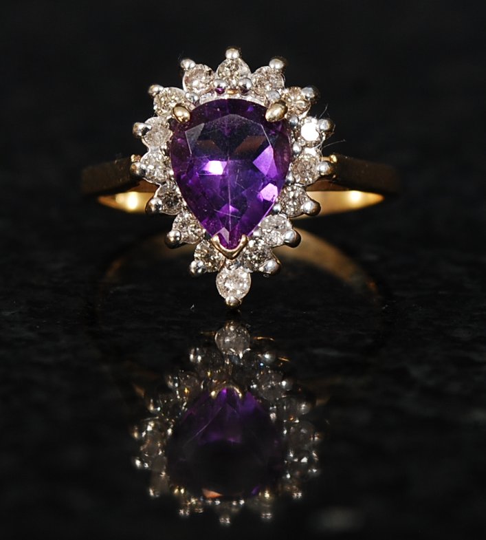 An 18ct gold amethyst and diamond ladies ring. The large amethyst stone with diamond set shoulders