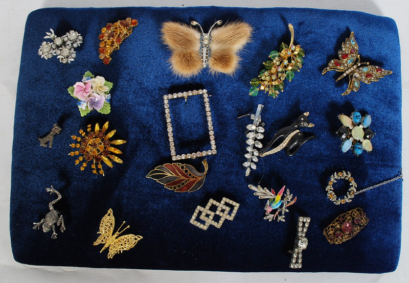 A selection of vintage brooches mounted of a velvet board.