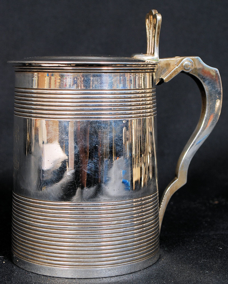 A heavy George III silver tankard of tapering form being decorated with ribbed bands and applied