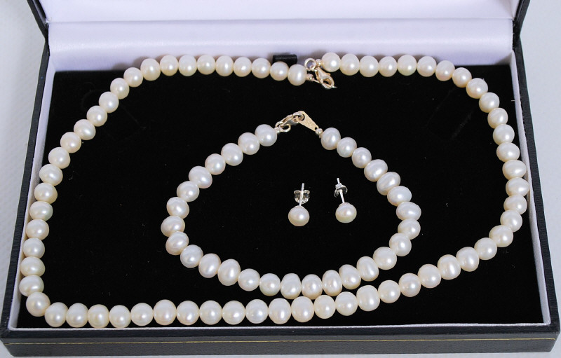 A freshwater pearl necklace, bracelet and matching earrings. white metal silver clasps stamped 925.