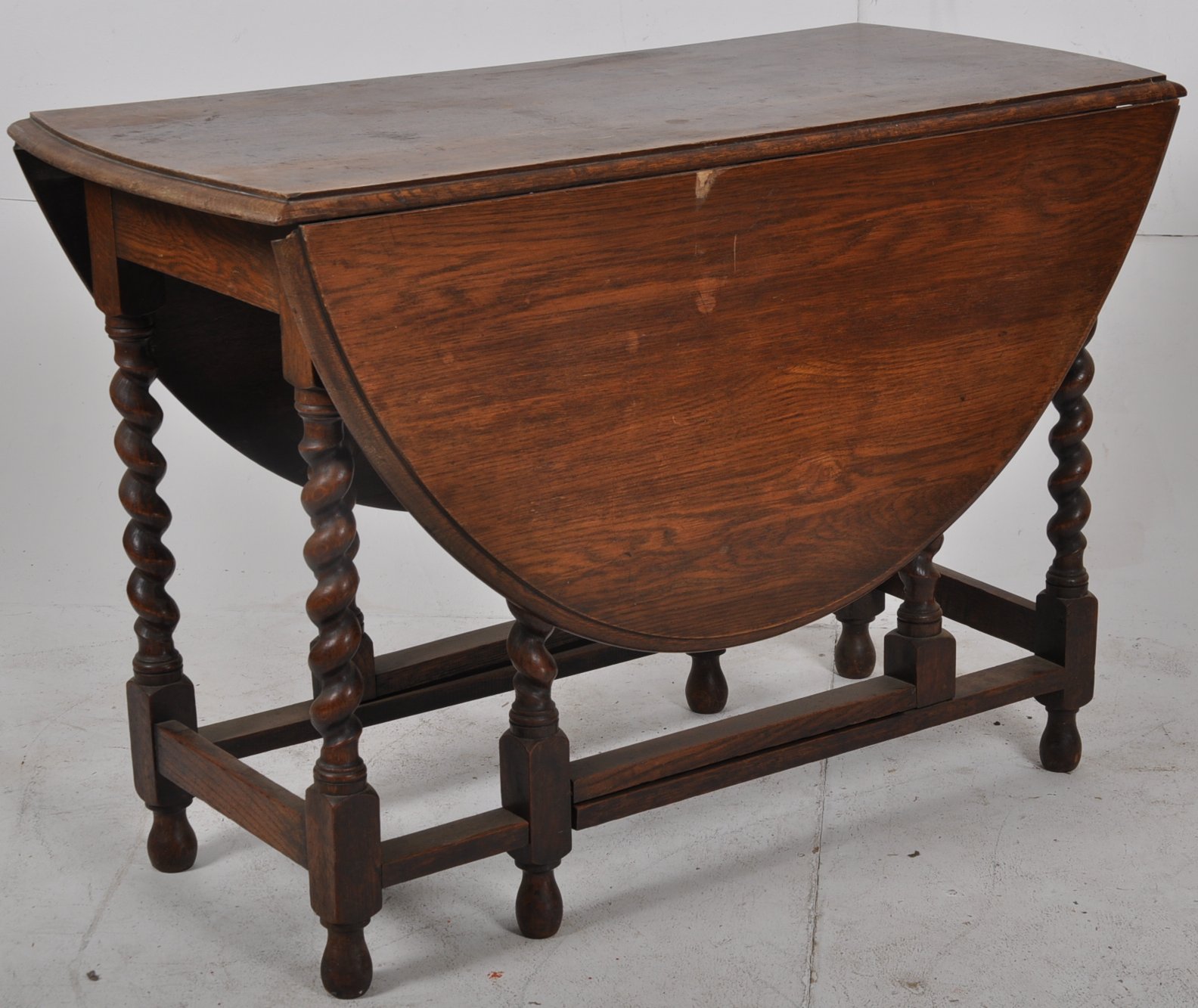 1930's large oak barley twist dining table. The barleytwist legs united by stretchers having drop