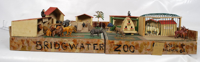 A vintage home made well detailed childs toy zoo with a quantity of lead animals and buildings etc