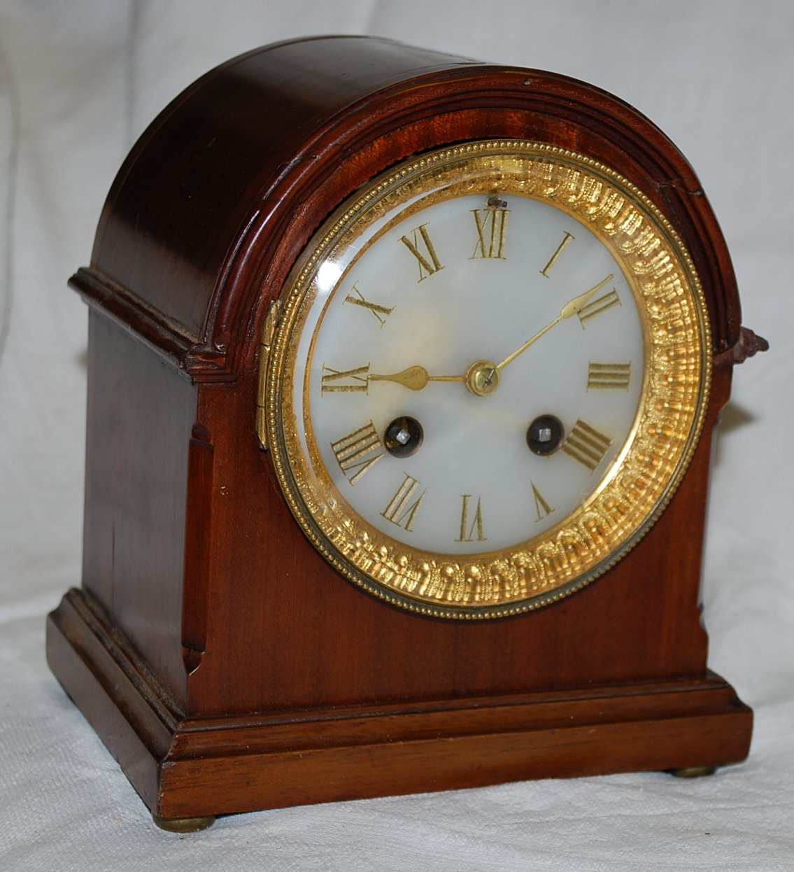 A mahogany arched top mantel clock striking on a gong