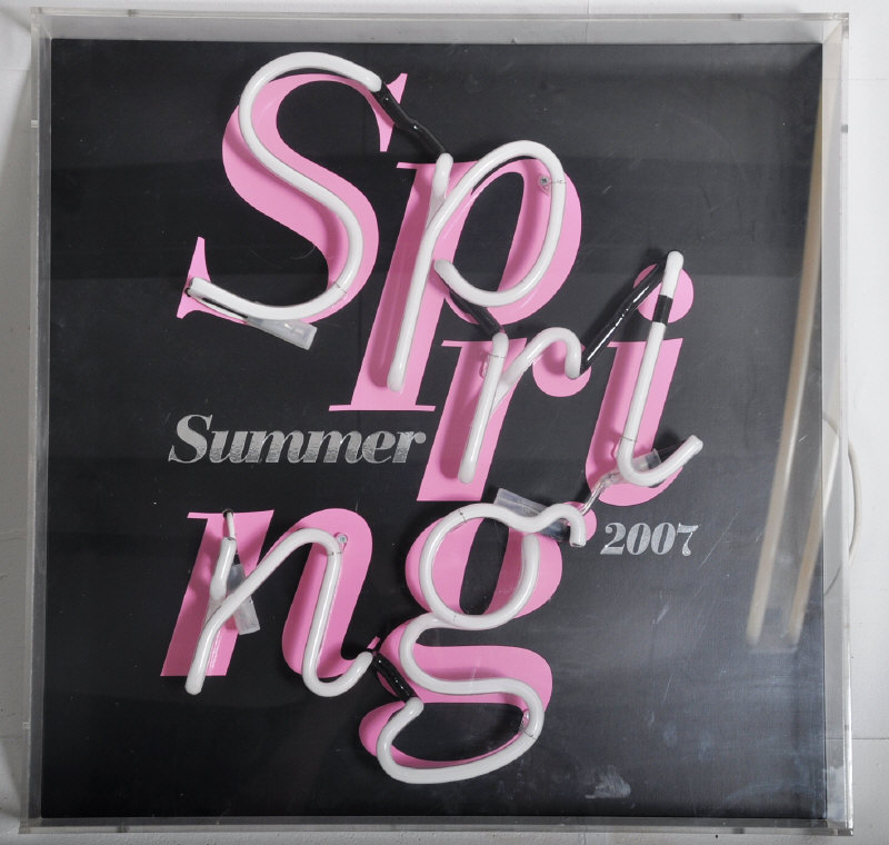 A retro acryllic cased pink neon light ' Spring Summer 2007 ' on black background. 60cms High x