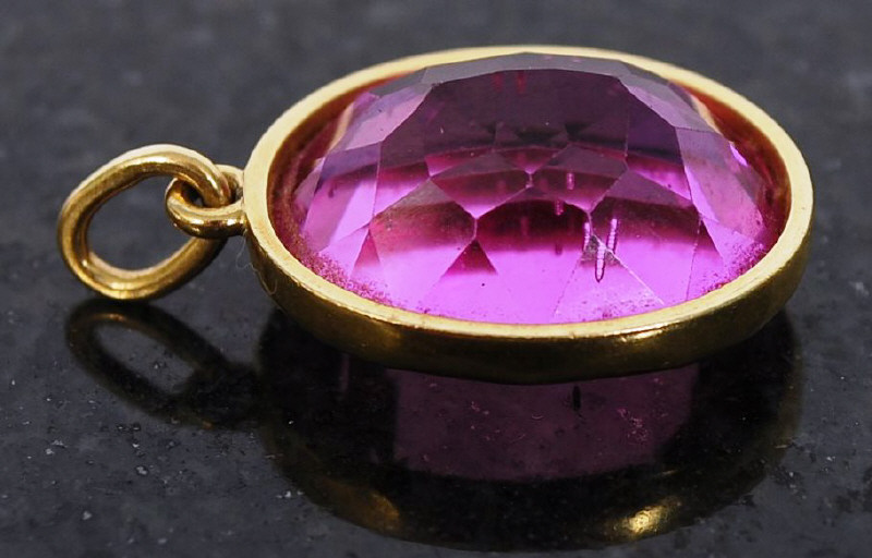 A large pink sapphire pendant set within a 18ct gold surround having clasp to the top. 8.2g