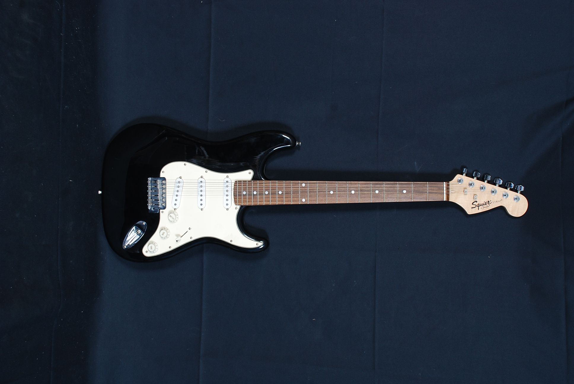 An electric Squire Fender Strat guitar together with an un-associated case
