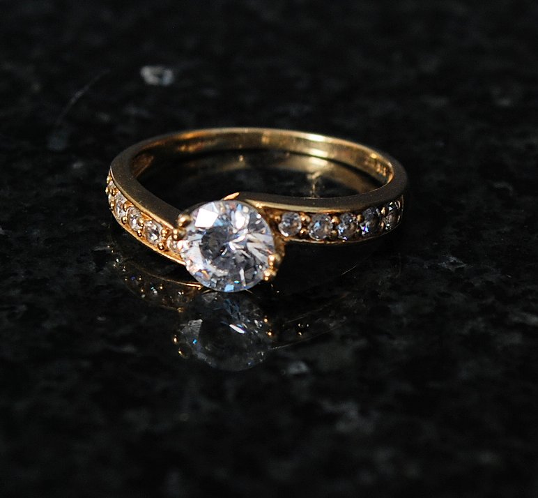 A 9ct gold ladies dress / cocktail cross over ring . The inset diamond being channel set to centre