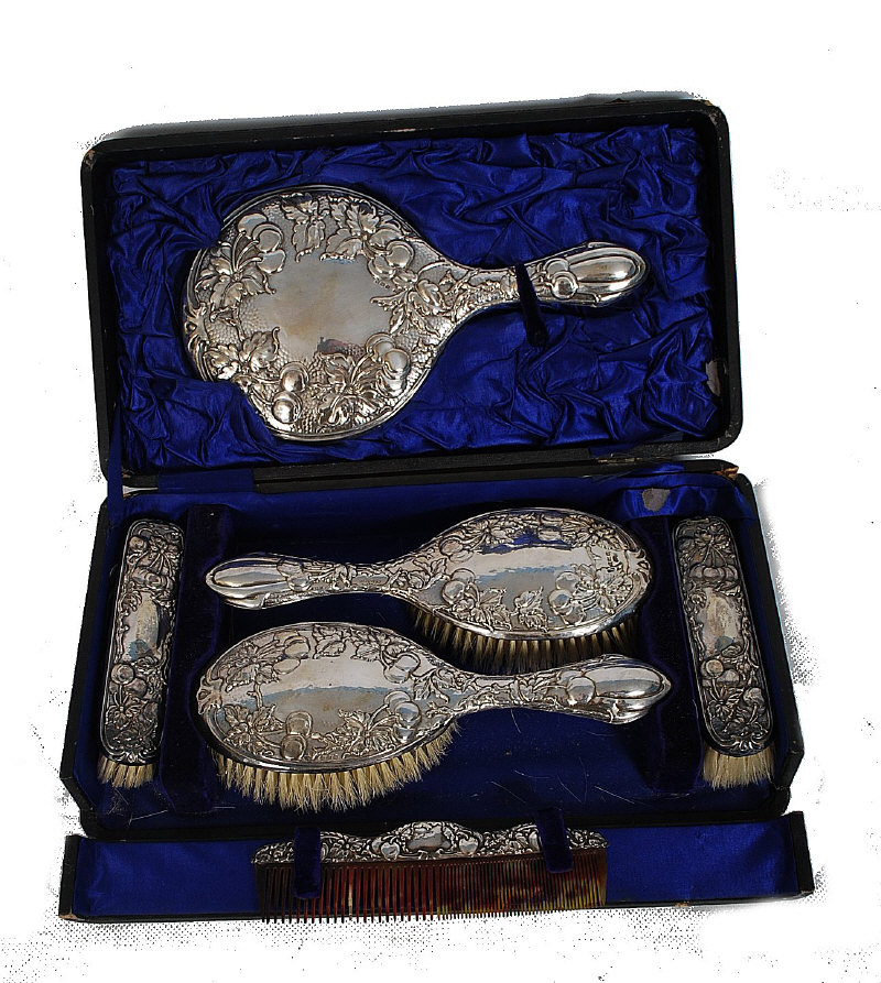 An early 20th century hallmared solid silver dressing table set in the rococo style complete in