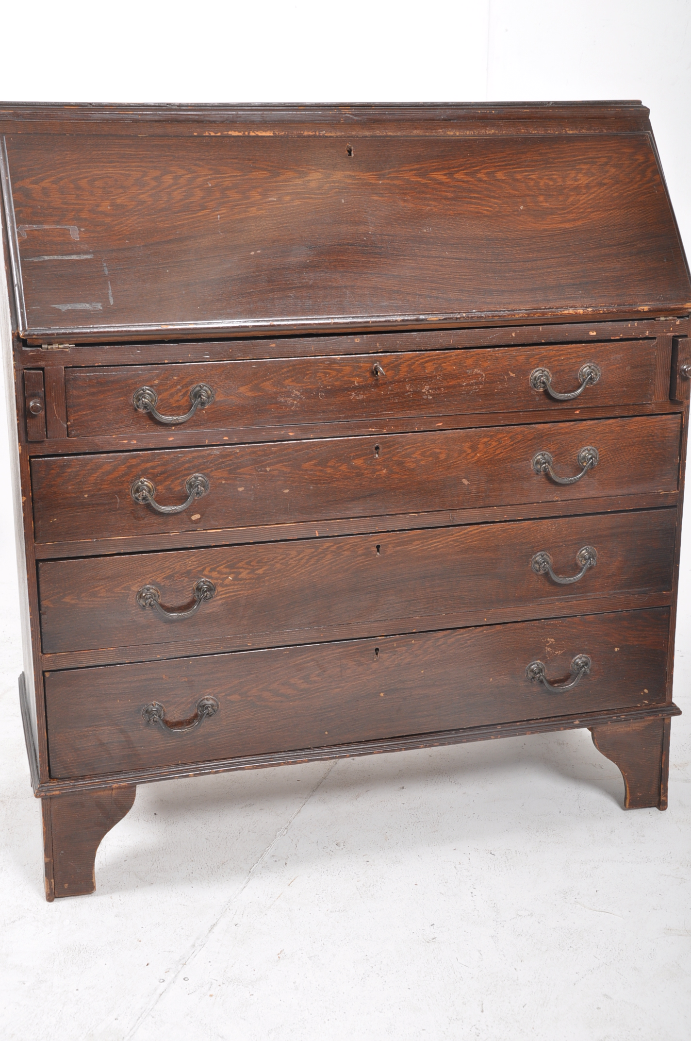 A 1930's carved oak bureau. A series of drawers beneath fall front slope atop having appointed