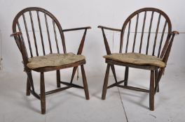 A pair of Ercol 1970`s Fireside beech and elm wood low chairs. Turned legs united by stretchers