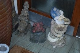 A collection of garden ornaments to include 4 garden gnomes of various styles together with a pig