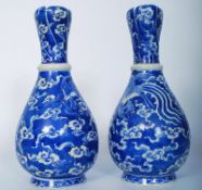 A pair of early 20th century Kangxi period blue and white vases. Decorated with swooping Birds and