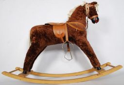 A 1950`s wooden rocking horse with sadle and reigns. 105cm x 80cm