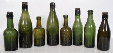 A collection of brown and green glass bottles to include Warn & Sons of Tetbury, CR Luce of