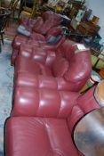 A Burgandy leather 3 piece suite to include a 3 seat sofa and the 2 matching armchairs