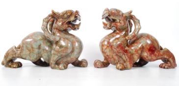 A pair of large Chinese red soapstone dragons. The brick red and tan soapstone carved intricately