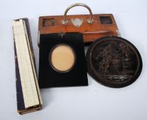 A late Victorian ebonised miniature picture frame with oval glass inset. Together with a desk tidy,