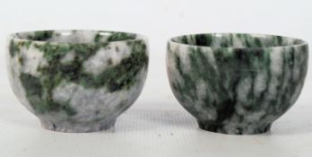 A pair of jade style tea bowls of mottled grey colouring with green highlights.