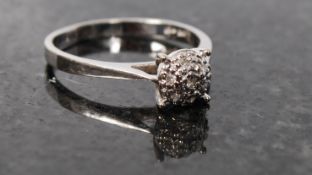 A 10ct white gold diamond cluster ring.