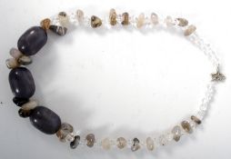 A hardstone necklace, with stones of varying tone and size.