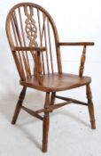 A Windsor style wheel back beech wood carver chair with decorative backrest. H96cm x W53cm x D50cm.
