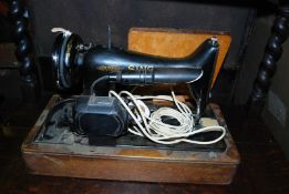 An early 20th century oak cased electric Singer sewing machine.