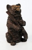 A 20th century match strike in the form of a climbing bear, the hinged neck revealing interior