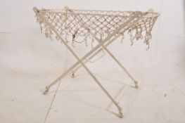 A Victorian shabby chic painted cast iron folding childs cot / day bed stand. The x-frame stand