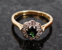 An 18ct gold flower ring having inset green stone with an 8 stone diamond surround. 4.7g / Size U