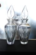 A pair of glass perfume scent bottles with etched decoration and polised bases. 17cm tall