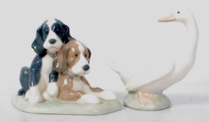 Two Nao Lladro figurines; one of two hounds, the other of an alert goose. 13cm tall.