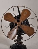 1920's Electronic desk fan. Four wire encased brass blades standing on a heavy black cast iron base,