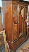 An Edwardian mahogany Art Nouveau double wardrobe. Single drawer to base having a central mirror