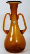 A twin handled amber coloured glass vase by Royal Leerdam, Holland. 29cm tall.