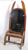 An unusual large hand carved oak hall settle having mirror back upright under arched top. Elbow