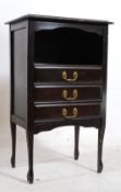 An Edwardian ebonised mahogany music / side / hall cabinet. The shaped supports having a series of