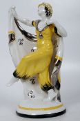 A decorative Art Deco dancing lady figurine having cape and hat with good vivid colours standing