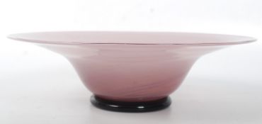 A large pink decorative art glass bowl with a darker coloured glass pontil base. 32cm wide.