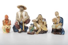 A set of 5 pottery Chinese figurines, all seated men in various sizes. 17cm tall.
