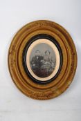 A Victorian photograph of a couple, in a gilt and plaster frame. 27cm x 23cm