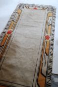 A decorative 1930's Art Deco cream rug with tassled ends having decorative geometric colourful