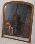 A large Victorian gilt framed overmantle mirror. The gilt decorated frame having shaped sides with