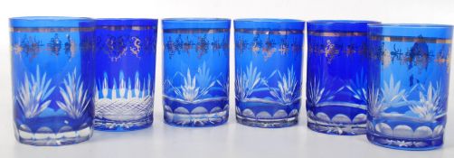 A set of six small etched blue coloured drinking glasses.