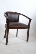 An unusual 1950's leather office armchair. The squared legs supporting a leather seat with shaped