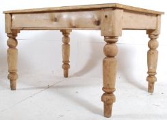 A Victorian large pine kitchen dining table having thick ring turned legs supporting a fitted frieze