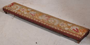 A Victorian mahogany and tapestry upholstered long and low footstool. Bun feet with gadrooned